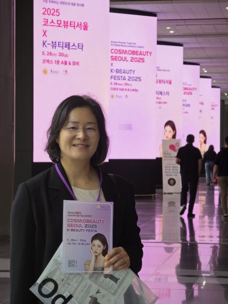 Sohyun Park holding a brochure at the Cosmobeauty Seoul K-Beauty Festa 2025 expo