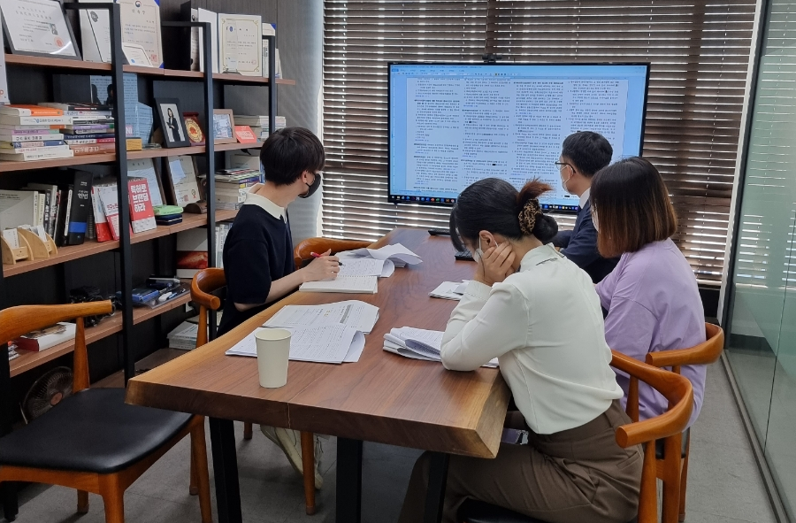 Sarang IP team reviewing a case around a table in the firm's book-lined office