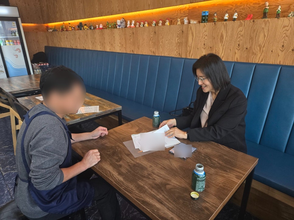 Attorney Sohyun Park reviewing documents with a client across a table during a consultation