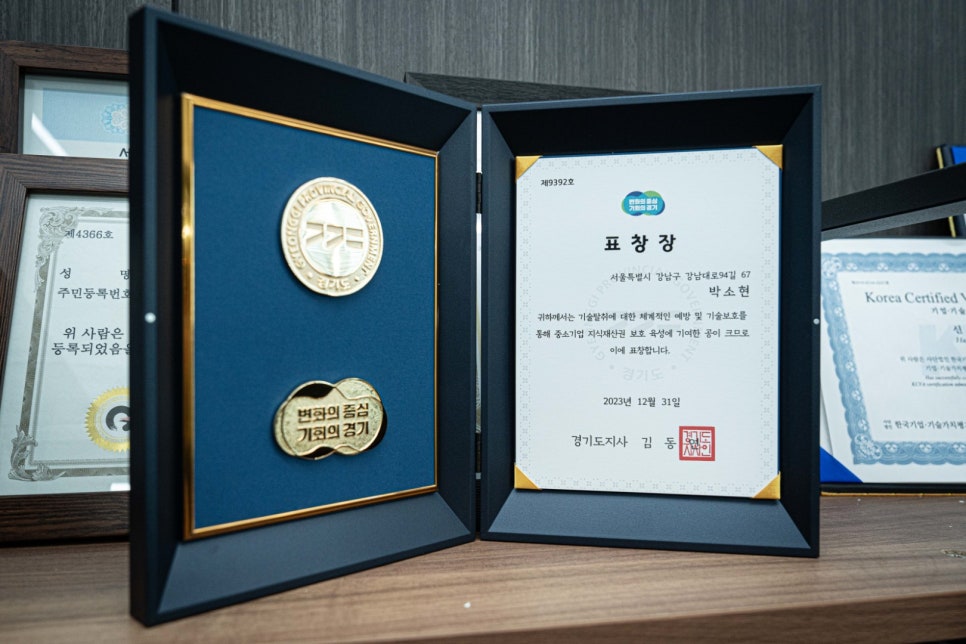 Commendation certificate and patent-attorney medals displayed in the Sarang IP office